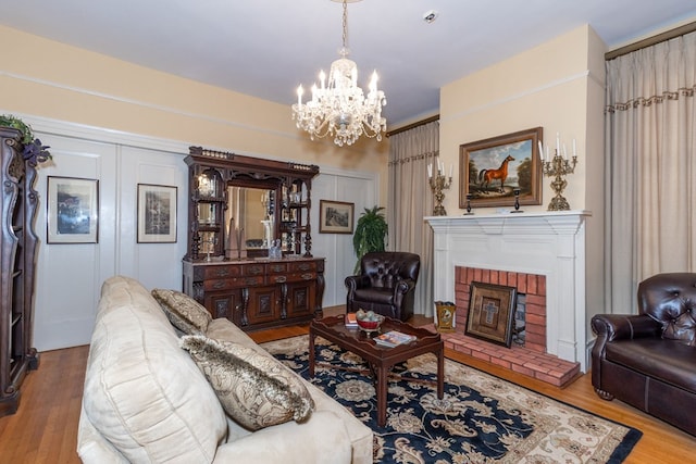 living room with a chandelier, light wood-type flooring, and a brick fireplace