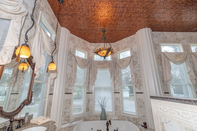 bathroom featuring brick ceiling, a wealth of natural light, and sink