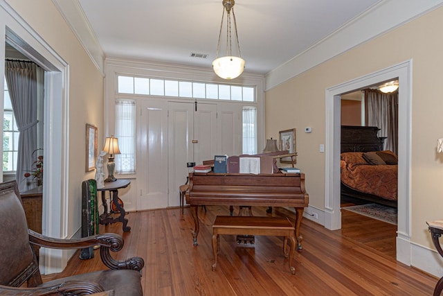 foyer entrance with crown molding and wood-type flooring