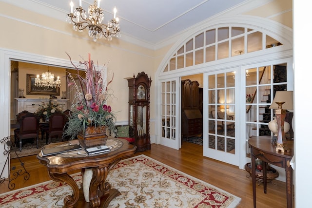 interior space with hardwood / wood-style floors, a notable chandelier, and french doors