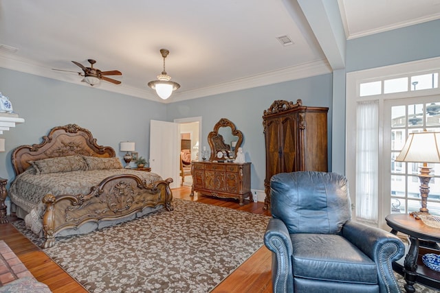 bedroom featuring ceiling fan, wood-type flooring, crown molding, and multiple windows