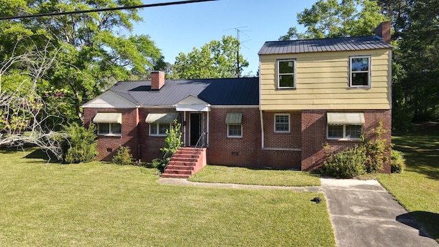 view of front of house with a chimney, a front lawn, brick siding, and metal roof