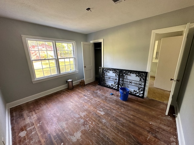 unfurnished bedroom with wood finished floors and baseboards