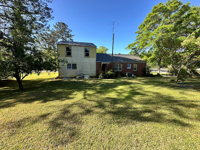 back of property with a lawn and metal roof