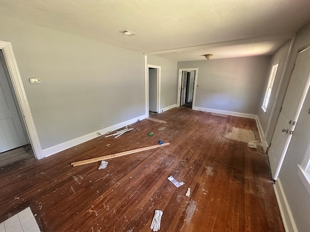 unfurnished room with baseboards, visible vents, and wood-type flooring