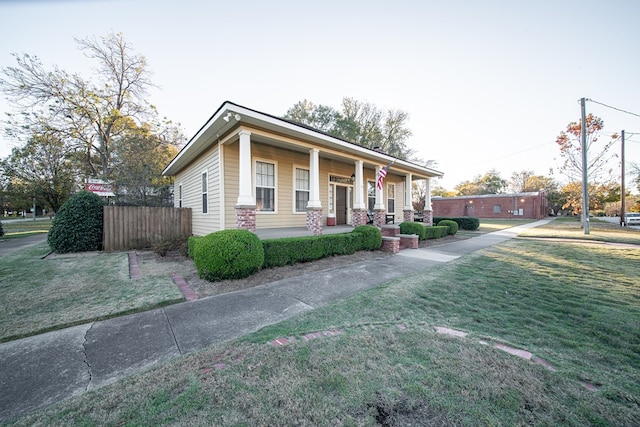 view of front of home featuring covered porch and a front lawn