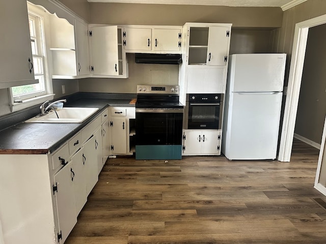 kitchen with stainless steel electric range, freestanding refrigerator, a sink, under cabinet range hood, and black oven