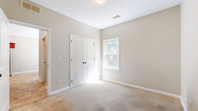650 Upland Ct, Columbus, GA 31907 - unfurnished bedroom featuring light colored carpet, baseboards, freestanding refrigerator, and a closet