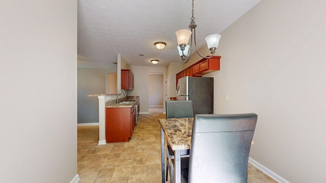 650 Upland Ct, Columbus, GA 31907 - kitchen with freestanding refrigerator, a sink, a chandelier, baseboards, and pendant lighting
