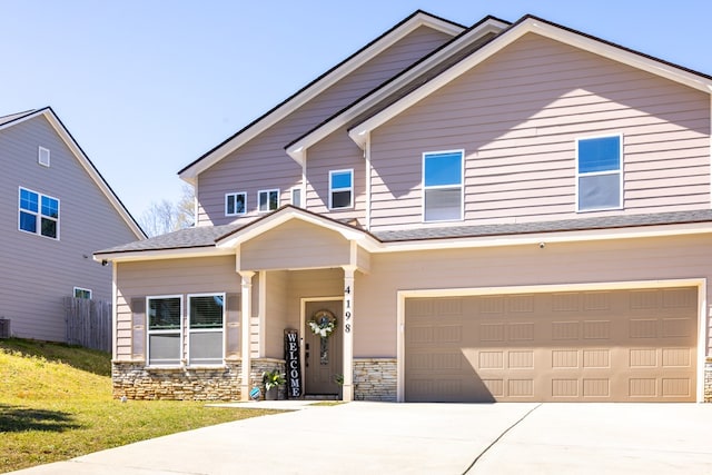 view of front of property with a garage, driveway, stone siding, and a front yard