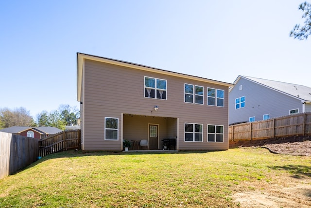 back of house featuring a fenced backyard and a yard