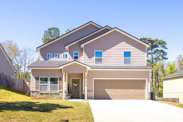 craftsman-style house featuring an attached garage, stone siding, fence, and driveway