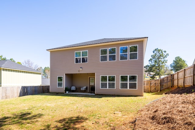 rear view of property with a lawn, a patio area, and a fenced backyard