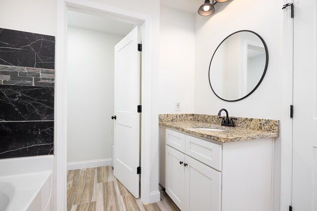 full bath with a tub to relax in and vanity
