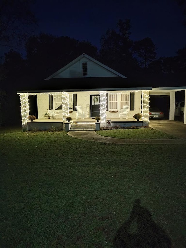 view of front of house with a porch, a yard, and a carport