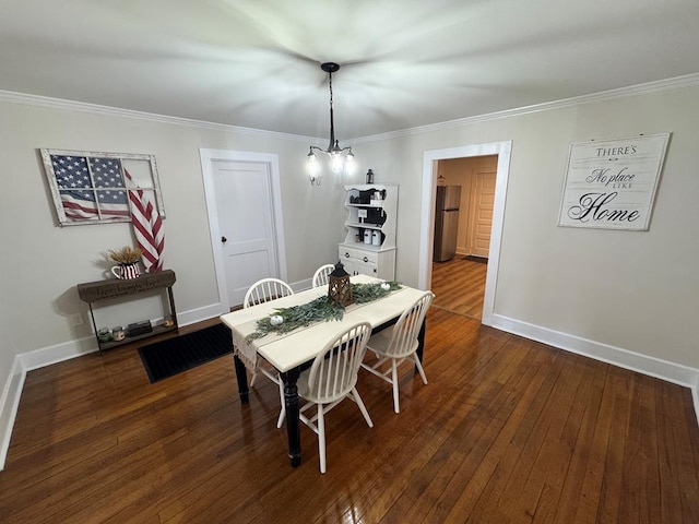 dining room with crown molding, dark hardwood / wood-style floors, and an inviting chandelier