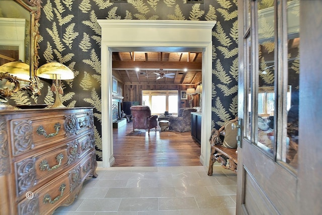 foyer entrance with ceiling fan, light hardwood / wood-style floors, and beam ceiling