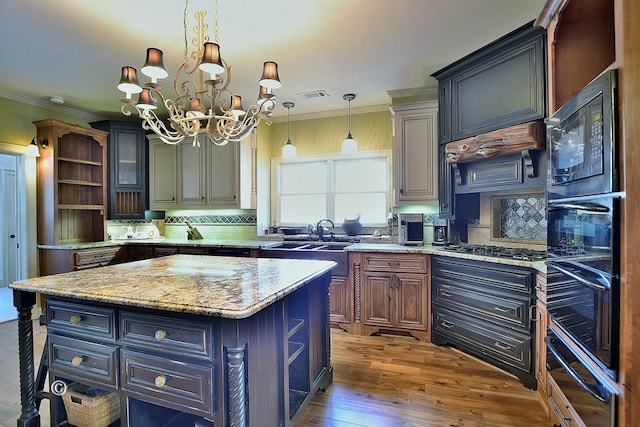 kitchen with light stone counters, a center island, a chandelier, and dark hardwood / wood-style floors