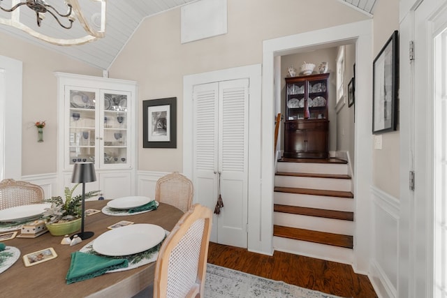 dining room with an inviting chandelier, vaulted ceiling, dark wood-type flooring, and wood ceiling