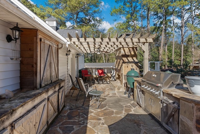 view of patio featuring a pergola, a grill, and an outdoor kitchen