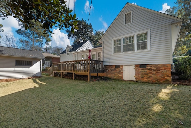 back of house featuring a lawn and a deck