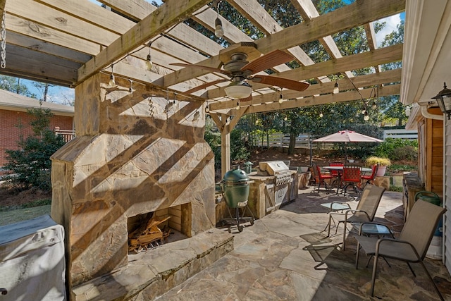 view of patio / terrace featuring ceiling fan, an outdoor kitchen, a pergola, an outdoor stone fireplace, and area for grilling