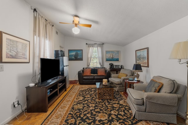 living room featuring a textured ceiling, light hardwood / wood-style floors, ceiling fan, and lofted ceiling