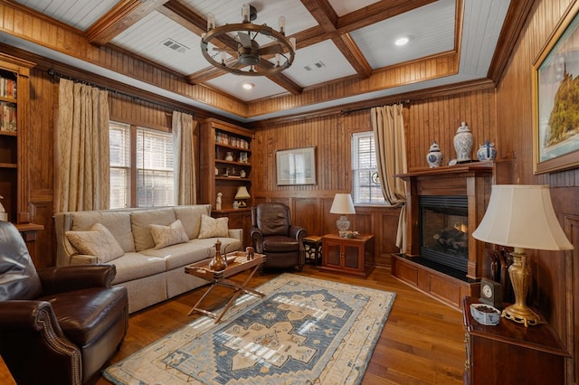 living room with hardwood / wood-style floors, built in shelves, ceiling fan, and coffered ceiling