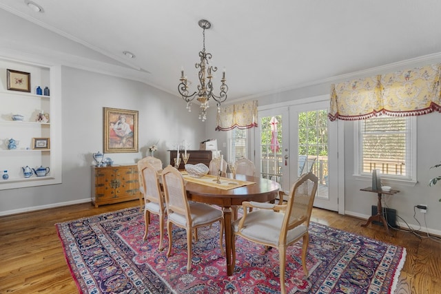 dining area featuring hardwood / wood-style floors, french doors, ornamental molding, and vaulted ceiling