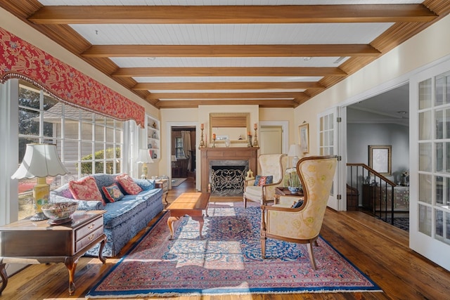 living room with a high end fireplace, beam ceiling, hardwood / wood-style flooring, and french doors