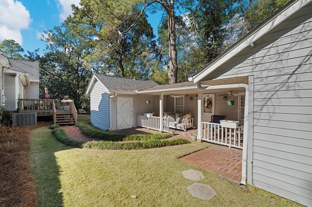 view of yard featuring a porch, central air condition unit, and a wooden deck