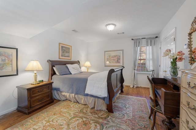 bedroom with a textured ceiling and light hardwood / wood-style flooring