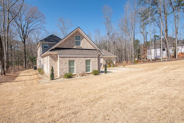 view of front of property featuring a shingled roof and brick siding