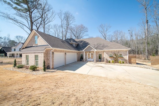 view of front facade with driveway, brick siding, an attached garage, and a shingled roof