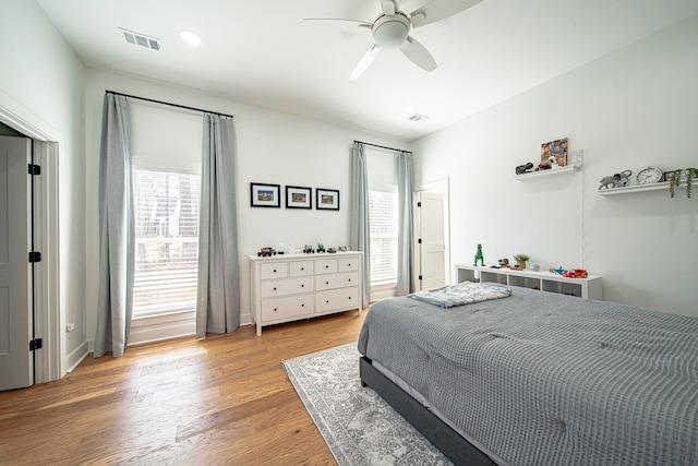 bedroom with light wood finished floors, visible vents, and a ceiling fan