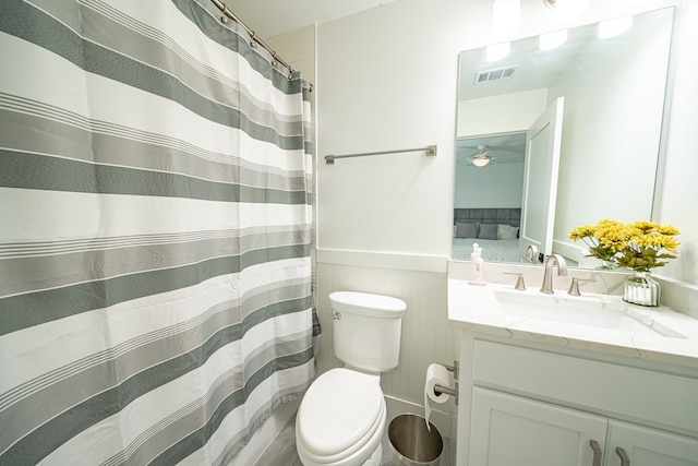 full bath featuring visible vents, toilet, wainscoting, connected bathroom, and vanity