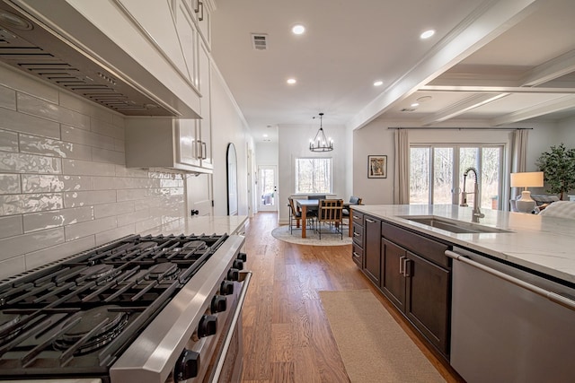 kitchen featuring light stone counters, dark wood finished floors, custom exhaust hood, a sink, and dishwasher