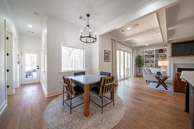 dining room featuring a wealth of natural light, visible vents, wood finished floors, and beamed ceiling