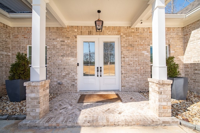 property entrance featuring french doors and brick siding