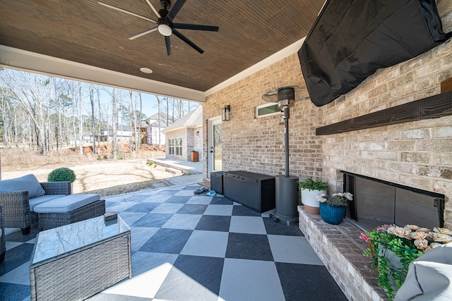 view of patio featuring an outdoor brick fireplace and a ceiling fan