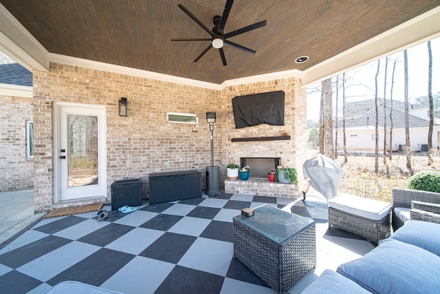 view of patio / terrace featuring an outdoor brick fireplace and ceiling fan