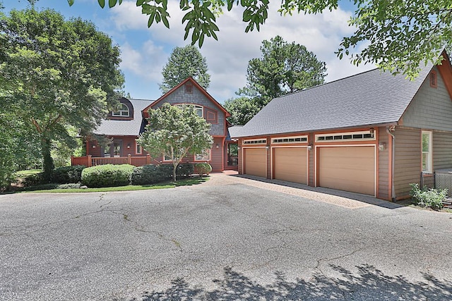 9250-11 River Rd, Fortson, GA 31808 - rustic home featuring an outdoor structure, a garage, asphalt driveway, and roof with shingles