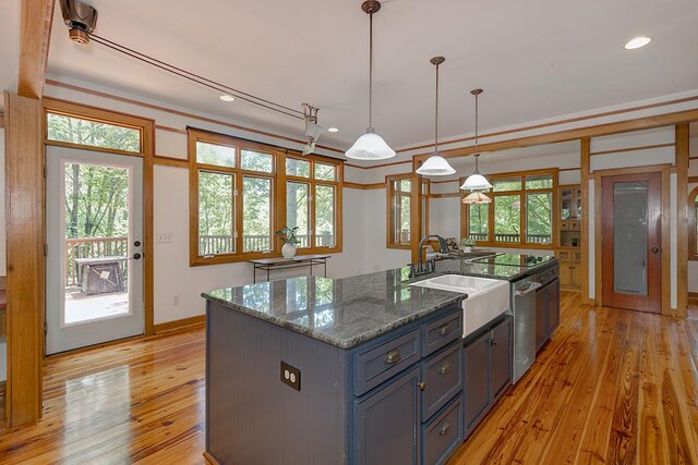 9250-11 River Rd, Fortson, GA 31808 - kitchen featuring stainless steel dishwasher, light wood-style flooring, dark stone counters, decorative light fixtures, and a center island with sink