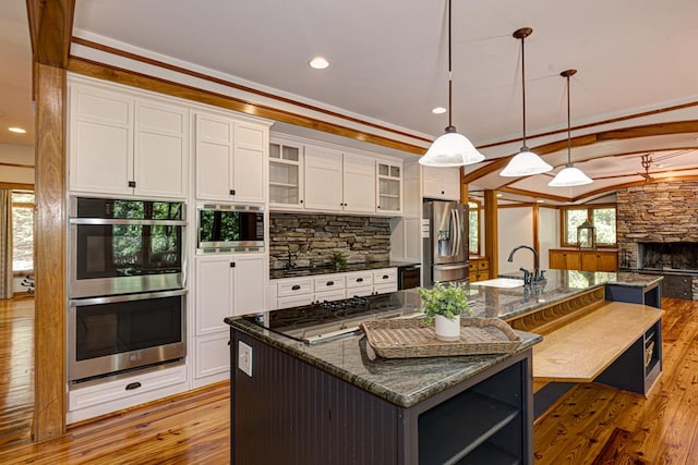 9250-11 River Rd, Fortson, GA 31808 - kitchen featuring appliances with stainless steel finishes, light wood-style flooring, white cabinets, a spacious island, and glass insert cabinets