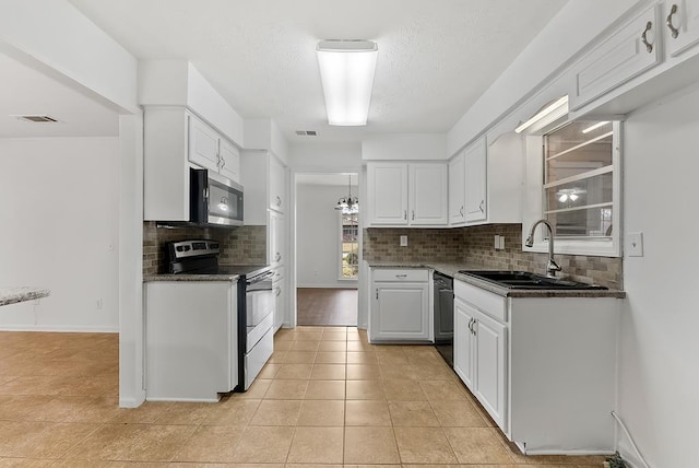 kitchen featuring sink, white cabinetry, tasteful backsplash, light tile patterned floors, and appliances with stainless steel finishes