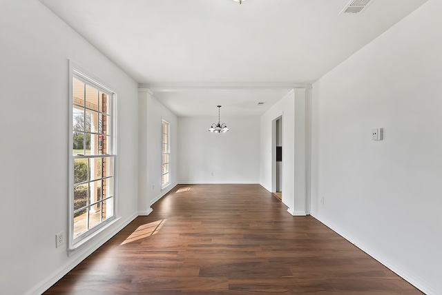 unfurnished room featuring a notable chandelier and dark hardwood / wood-style flooring