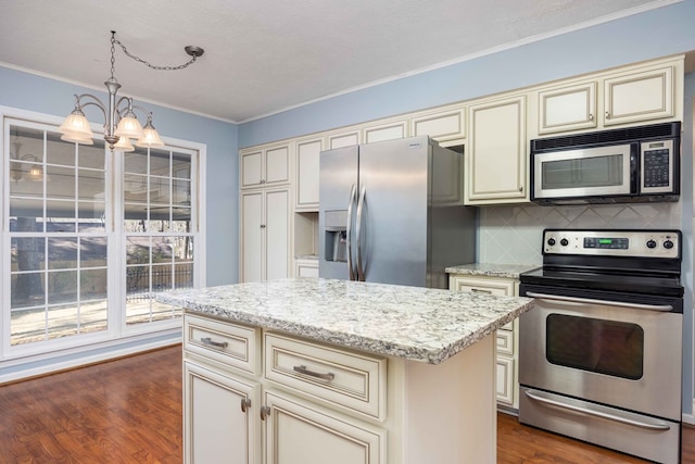 kitchen featuring appliances with stainless steel finishes, dark wood-type flooring, and cream cabinetry