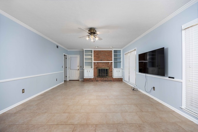 unfurnished living room with built in shelves, a fireplace, ceiling fan, and crown molding