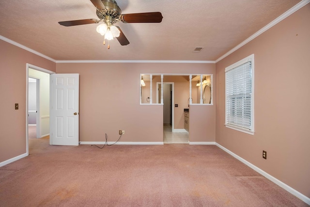 carpeted empty room with ornamental molding, a textured ceiling, and baseboards