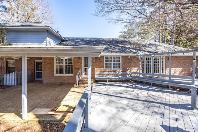 back of property featuring a deck and brick siding